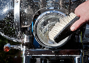 hand of biker washing headlight