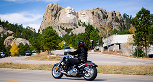 Motorcycle riding past Mount Rushmore